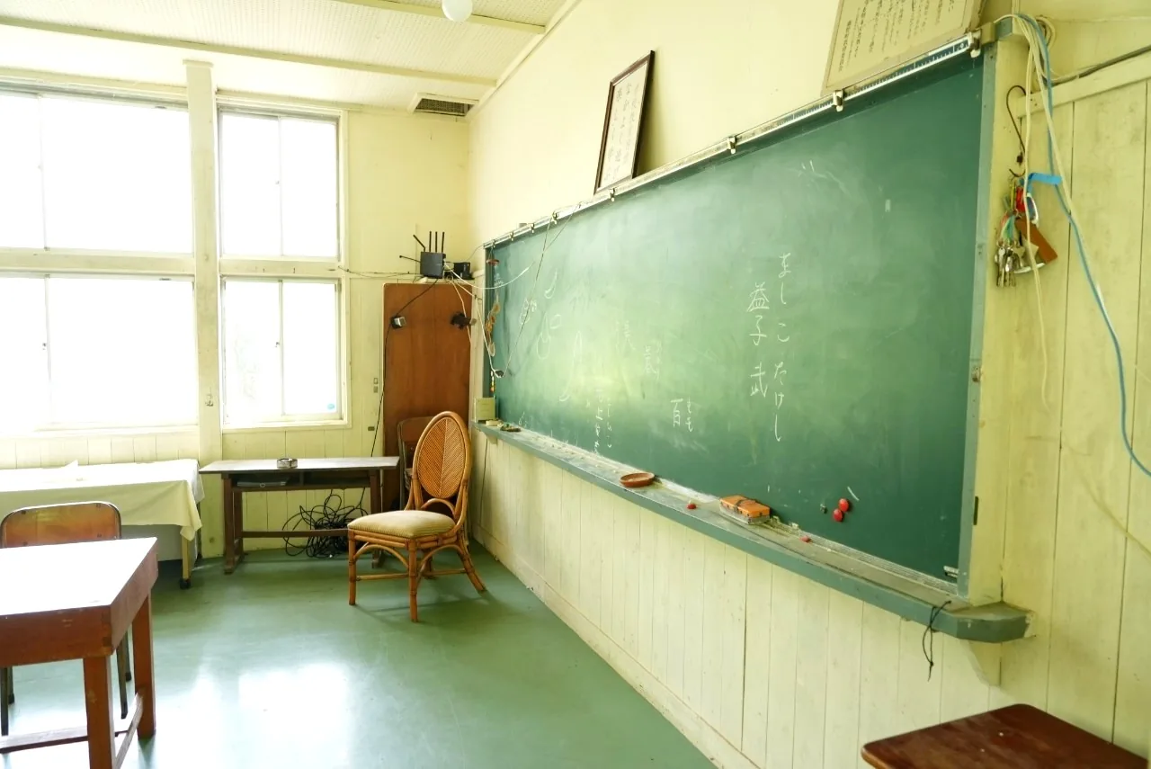 旧牧郷小学校の教室。黒板と木の机が残っている